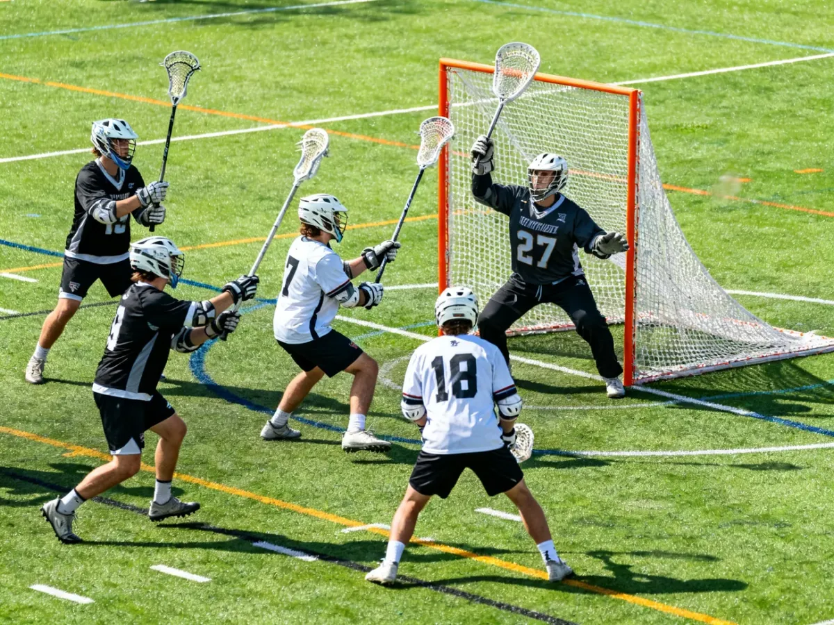 Męski mecz lacrosse na trawiastym boisku w pobliżu bramki
